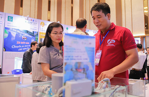 Anh Đào Phước Xoàn (áo đỏ) giới thiệu cho khách tham quan về cách vận hành hệ thống nuôi tôm thông minh. Ảnh: Nguyễn Đông.